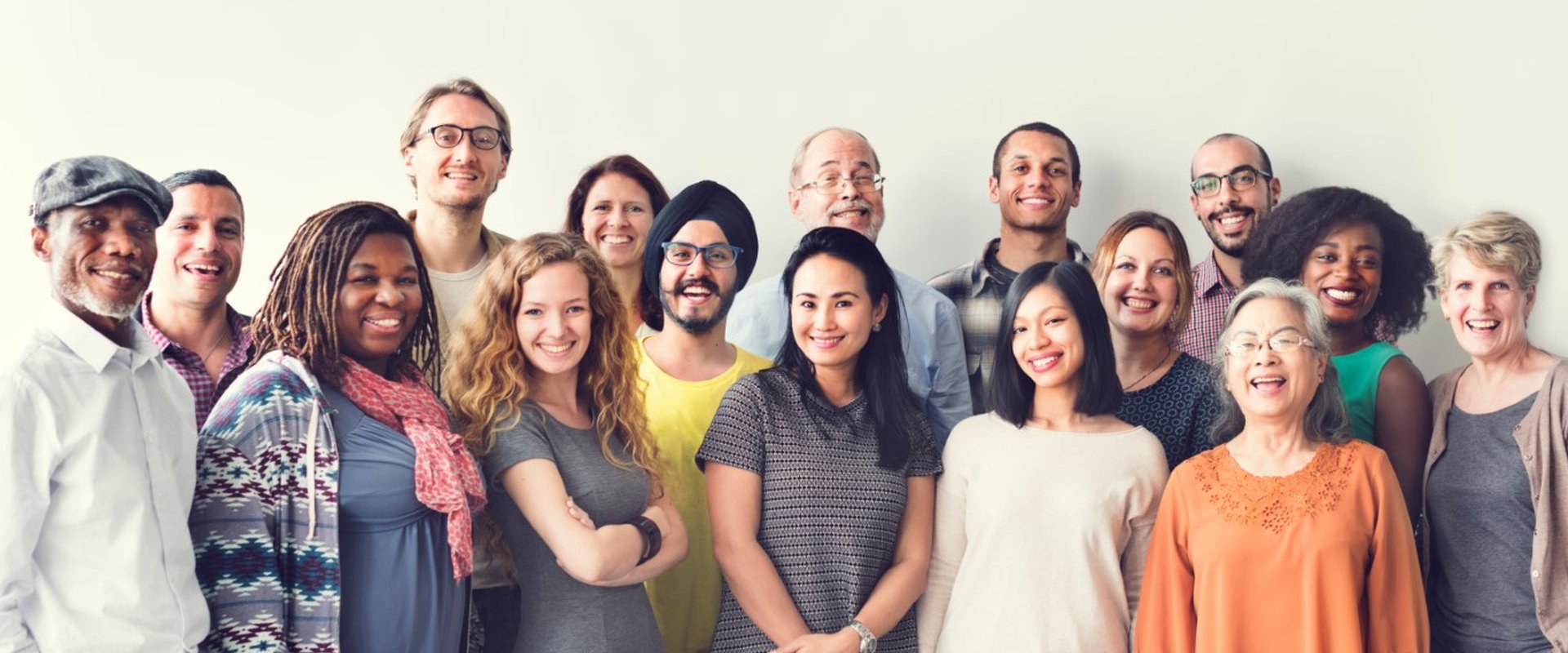 Diverse group in unique outfits, all smiling together.